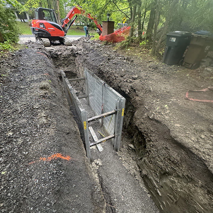 Excavation pour égout et aqueduc dans une grande cour